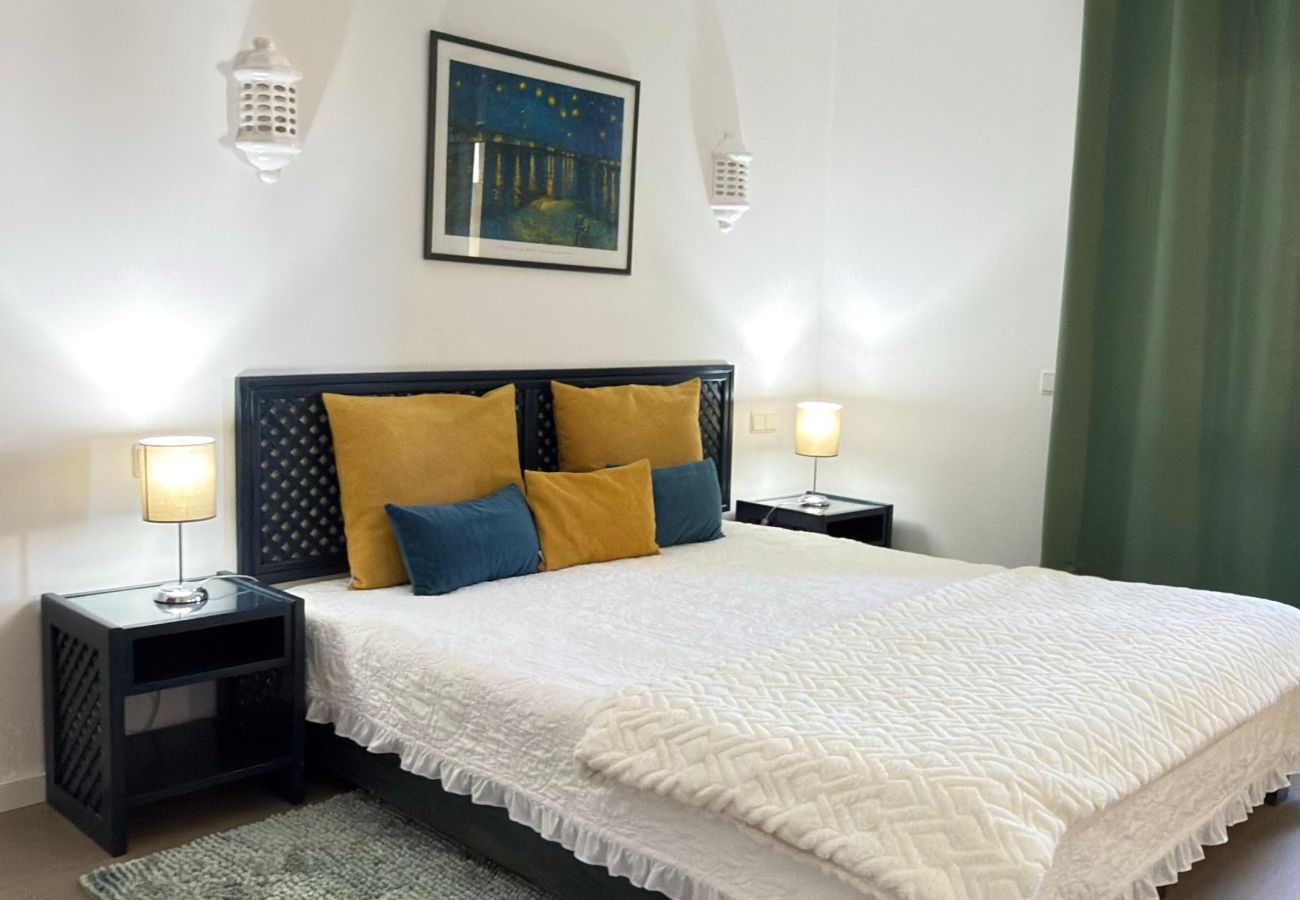  Quarto com cama de casal e cortinas verdes